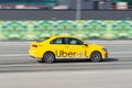 Yellow taxi car with the Uber logo fast moving on the street. Side view of taxi in motion. Rapid and inexpensive means of getting Royalty Free Stock Photo