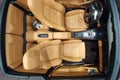 Moscow, Russia - May 05, 2019: Beige interior of a Porsche 911 Convertible. View from above Wooden steering wheel and conrol panel