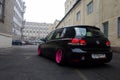 Moscow, Russia - May 08, 2019: A black tuned and understated Volkswagen Golf 6 with bright pink handmade custom wheels stands on