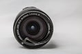 Moscow, Russia - May 13, 2019: Canon zoom tele foto lens 18-135mm with a broken protective glass filter on a gray background.