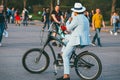 Moscow, Russia - may 1, 2018. Fashionable businessman in a hat, light jacket on a Bicycle, looking at the phone, against