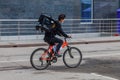 Food delivery courier delivering food on bicycle. Cyclist carrying backpack with food and drinks. Fast delivery within the city