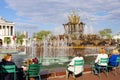 People relax by the fountain `Stone Flower` in Moscow at the Exhibition of Economic Achievements.