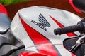 Moscow, Russia - May 04, 2019: Glossy red and white fuel tank of sports motorcycle with Honda emblem closeup. Moto festival