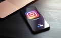 MOSCOW, RUSSIA - MAY 03, 2022: iphone lying on a wooden table, on the screen Instagram social application logo, which