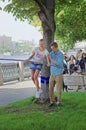 Man helps young woman in balancing during her tightrope walk in park Gorkogo in Moscow