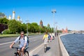 Moscow cityscape around Kremlin Embankment, with Kremlin on the left hand side, tourists ride bicycles.