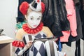 Girl clown in makeup sitting in the dressing room resting. Royalty Free Stock Photo