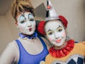 Close-up portrait of a clown girl in the form of harlequin and her partner.