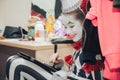 Girl clown in makeup sitting in the dressing room resting. Royalty Free Stock Photo