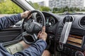 Moscow, Russia, 24/05/2020: Men`s hands on the steering wheel of a Mercedes. Medical mask in a car interior. Coronavirus pandemic