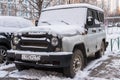 MOSCOW, RUSSIA,NOVEMBER,28.2018:Abandoned snow covered car UAZ Hunter in the courtyard of an apartment building