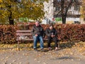 Drunk homeless couple sit on a bench near the subway