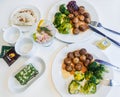 Moscow, Russia, November 2018: Food for two at IKEA restaurant: plates with meat balls with gravy and broccoli, cups and tea bags