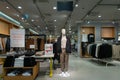 Interior in a men`s clothing store. Mannequins in modern costumes. Inscriptions in Russian -