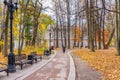 Moscow, Russia - October 16, 2019: Autumn in Tsaritsyno Park in Moscow. Footpath with benches against trees with yellow leaves in Royalty Free Stock Photo