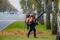 Moscow. Russia. October 11, 2020 Community workers use a blower to remove fallen leaves from city streets and parks.