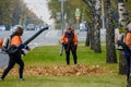 Moscow. Russia. October 11, 2020 Community workers use a blower to remove fallen leaves from city streets and parks.