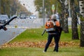 Moscow. Russia. October 11, 2020 Community workers use a blower to remove fallen leaves from city streets and parks.