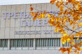 Moscow, Russia - October 03, 2019: Facade of New Tretyakov Gallery close-up against branch of tree with yellow leaves in sunlight