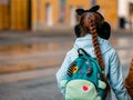 Moscow, Russia - October 19, 2019: A girl with a braided pigtail in funny hat in shape of an animal with ears and with a blue