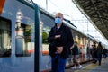 Moscow. Russia. October 4, 2020. A lone bald man in a protective medical mask and headphones walks along railway