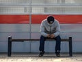 Moscow. Russia. October 4, 2020. A lone man wearing a protective medical mask sits on a bench of a railway station