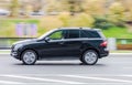 Mercedes-Benz ML W164 car rides on the road. Black SUV with woman driver rushes along the street