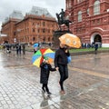 Moscow, Russia, October, 12, 2019. Mother and child walk under bright umbrellas on Manezhnaya square in rainy weather Royalty Free Stock Photo