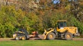 MOSCOW, RUSSIA - OCTOBER 22, 2018: New Holland L218 mini-loader and SDLG LG936L wheel loader are involved in foliage cleaning in a