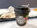 Moscow, Russia - October 12, 2021: A paper disposable takeout cup of coffee on a table in Burger King fastfood Royalty Free Stock Photo