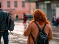 Moscow, Russia - October 19, 2019: Red-haired young plump woman holds a smartphone in her hand and walks along the street. People Royalty Free Stock Photo