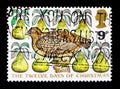 MOSCOW, RUSSIA - OCTOBER 3, 2017: A stamp printed in Great Britain shows A Partridge in a Pear Tree, Christmas 1977 - TheTwelve d Royalty Free Stock Photo