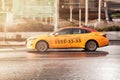 Taxi car Hyundai Sonata speeding on city road. Orange Ritm taxi car fast moving on the street. Side view of taxi in motion Royalty Free Stock Photo