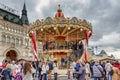 Moscow, Russia - October 05, 2019: Two-storey carousel against GUM State Department Store building on Red Square at cloudy autumn