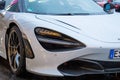 Moscow, Russia - October 9, 2019: White McLaren 720S in the parking lot. Under rain. Closeup of headlight
