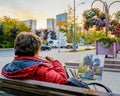 Moscow. Russia. October 1, 2020 A woman artist paints a picture sitting on a bench on a city street. Autumn evening