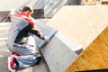 A worker mounts a bitumen roof on a sample. Modern roofing mater