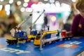 Moscow, Russia - October 04, 2019: yellow electric lego train with cranes. on background child plays with it in blur