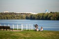 People on the nature. little girl having a picnic with little brother in a stroller on the river bank in the park. Royalty Free Stock Photo