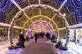 28.12.2019. Moscow.Russia.People walking through beautiful bright light tunnel in Moscow park during new year illumination