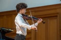 A boy violonist on the stage.