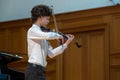 A boy violonist on the stage.