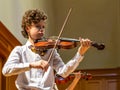 A boy violonist on the stage.