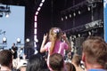 Back view of little girl sitting on parent`s shoulders and showing a rocker goat at concert at the City Day in Moscow