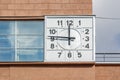 Moscow, Russia - September 21, 2019: Big street clock with white dial and black numerals on the building wall close-up in sunlight Royalty Free Stock Photo
