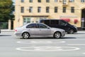 BMW E39 5-series car in the city street in motion. Old silver sedan fast speed drive on city road Royalty Free Stock Photo