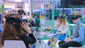 Group of teenagers using virtual reality headset at technology show