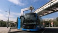 Moscow, Russia-September 2017:The concept of urban transport .Blue electric bus at the charging station.Modern train passing on th Royalty Free Stock Photo