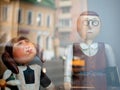 Dolls depicting a student and strict teacher with glasses and with a book in hand in a window of a Moscow Puppet Theater. Building